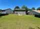 This home features a large grassy backyard, surrounded by neighboring homes and lush green trees at 234 Silver Arrow Cir, Austell, GA 30168