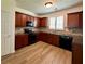 Cozy kitchen featuring wooden cabinets, black appliances, tile backsplash, and wood-look flooring at 234 Silver Arrow Cir, Austell, GA 30168