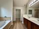 Luxurious primary bathroom with a double vanity, soaking tub, walk-in closet, and wood-look flooring at 234 Silver Arrow Cir, Austell, GA 30168