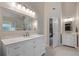 Bright bathroom with white vanity, marble countertop, and large framed mirror at 2772 Hillgrove Dr, Dacula, GA 30019