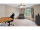 This bedroom has neutral walls, a ceiling fan, and a window that overlooks a tranquil, wooded area at 2772 Hillgrove Dr, Dacula, GA 30019