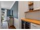 Convenient butler's pantry featuring custom cabinetry, butcher block counters, and a wine fridge at 2772 Hillgrove Dr, Dacula, GA 30019