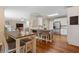 Open concept kitchen features an island with stools, stainless steel appliances, and wood flooring at 2772 Hillgrove Dr, Dacula, GA 30019