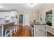 Kitchen with an island, stools, white cabinets, stainless steel appliances, and wood flooring at 2772 Hillgrove Dr, Dacula, GA 30019