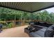 Covered patio with wood flooring, outdoor furniture, and a view of the backyard surrounded by trees at 2772 Hillgrove Dr, Dacula, GA 30019