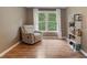 A cozy sitting room features hardwood floors, a light gray recliner, and built in shelving at 2772 Hillgrove Dr, Dacula, GA 30019