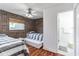 Cozy bedroom featuring brick wall, wood floors, ceiling fan and ensuite bathroom with shower at 549 Ne Parkway Ne Dr, Atlanta, GA 30308