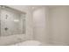 Elegant bathroom featuring a soaking tub with a rainfall showerhead and tiled marble surround at 165 Cooper E Cv, Fayetteville, GA 30215