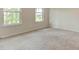 Empty bedroom featuring neutral carpet, white walls, and windows at 165 Cooper E Cv, Fayetteville, GA 30215