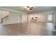 Spacious living room with hardwood floors flowing into a modern kitchen with white cabinetry and stainless appliances at 165 Cooper E Cv, Fayetteville, GA 30215
