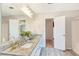 Bright bathroom featuring a dual granite vanity, a large mirror, and an open doorway at 1752 Shadybrook Ct, Lawrenceville, GA 30043