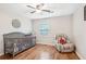 Comfortable Bedroom with hardwood floors, ceiling fan, gray crib and comfortable chair at 1752 Shadybrook Ct, Lawrenceville, GA 30043
