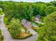 Aerial view showcases home with pool nestled in a tree-lined neighborhood with mature landscaping at 360 Spindle Ct, Sandy Springs, GA 30350