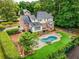 Aerial view of home with backyard pool, putting green, lush landscaping, and patio for outdoor living at 360 Spindle Ct, Sandy Springs, GA 30350