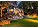 Scenic backyard with a pool, outdoor kitchen, putting green, and beautiful landscaping at 360 Spindle Ct, Sandy Springs, GA 30350
