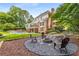 Spacious backyard with a fire pit, outdoor seating, lush landscaping, and a putting green near the pool at 360 Spindle Ct, Sandy Springs, GA 30350