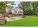 Captivating backyard boasts a pool, outdoor kitchen, putting green, and expansive green space at 360 Spindle Ct, Sandy Springs, GA 30350