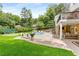Outdoor living space featuring a pool, putting green, a built in grill, mature trees, and plenty of seating at 360 Spindle Ct, Sandy Springs, GA 30350