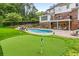 Expansive backyard featuring a pool, putting green, lush landscaping, and a charming outdoor living space at 360 Spindle Ct, Sandy Springs, GA 30350