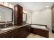 Luxurious bathroom featuring dual sinks, granite countertops, dark wood cabinetry, and a soaking tub at 360 Spindle Ct, Sandy Springs, GA 30350