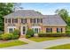 Elegant brick home with symmetrical design, manicured landscaping, and a curved driveway at 360 Spindle Ct, Sandy Springs, GA 30350