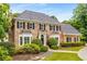 Stately two-story brick home with manicured landscaping, black shutters, and a well-maintained lawn at 360 Spindle Ct, Sandy Springs, GA 30350