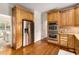 Kitchen with stainless steel refrigerator and double oven, wood cabinets, and hardwood floors at 360 Spindle Ct, Sandy Springs, GA 30350