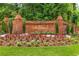 Brick community entrance sign with 'Spindlewick' in gold lettering, framed by flower beds and manicured landscaping at 360 Spindle Ct, Sandy Springs, GA 30350