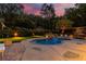 Twilight view of the pool featuring a stone waterfall feature and putting green enhanced by landscape lighting at 360 Spindle Ct, Sandy Springs, GA 30350