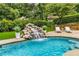 Inviting pool with a rock waterfall feature and ample space for lounging and enjoying the outdoors at 360 Spindle Ct, Sandy Springs, GA 30350