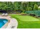 Backyard putting green alongside the pool and patio, creating an inviting space for outdoor enjoyment at 360 Spindle Ct, Sandy Springs, GA 30350