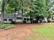 Traditional ranch home with a covered porch surrounded by mature trees at 1905 Sidneys Cv, Lawrenceville, GA 30043