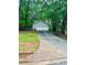 A detached two-car garage with a concrete driveway surrounded by green trees at 1905 Sidneys Cv, Lawrenceville, GA 30043