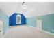 Finished bonus room with vaulted ceiling, bright accent wall, and carpet at 223 Falling Water Way, Woodstock, GA 30188