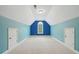 Finished bonus room with vaulted ceiling, bright accent wall, and carpet at 223 Falling Water Way, Woodstock, GA 30188
