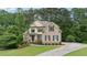 Inviting brick home featuring a green lawn, complemented by mature trees and tasteful landscaping at 223 Falling Water Way, Woodstock, GA 30188
