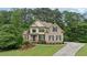 Beautiful brick home with manicured lawn and lush landscaping, set amongst mature trees at 223 Falling Water Way, Woodstock, GA 30188