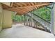 Covered back patio with concrete flooring and stairs leading to the upper level at 223 Falling Water Way, Woodstock, GA 30188