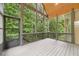 Covered screened porch overlooks mature trees at 223 Falling Water Way, Woodstock, GA 30188