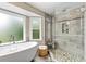 Bright bathroom features a soaking tub next to a shower with glass doors and pebble floor at 3710 Robinson Walk Ct, Marietta, GA 30068