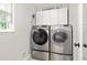 Bright laundry room with gray front load washer and dryer and white cabinets at 3710 Robinson Walk Ct, Marietta, GA 30068