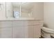 Bright bathroom features a large mirror over a double sink vanity and a toilet at 5352 Windfern Ct, Stone Mountain, GA 30088