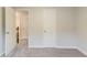 A bedroom with neutral walls and carpeting and a view of the hallway and stairs at 5352 Windfern Ct, Stone Mountain, GA 30088