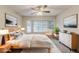 Staged bedroom showcasing a large window, ceiling fan, and neutral decor at 5352 Windfern Ct, Stone Mountain, GA 30088
