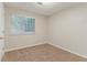 A bedroom with neutral carpeting, white walls and a window at 5352 Windfern Ct, Stone Mountain, GA 30088