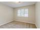 This bedroom has a window and neutral carpeting at 5352 Windfern Ct, Stone Mountain, GA 30088