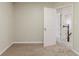 A bedroom with carpeting, neutral walls, and a view of the hallway and stairs at 5352 Windfern Ct, Stone Mountain, GA 30088