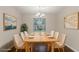 Staged dining room with modern chandelier, seating for eight, and natural light at 5352 Windfern Ct, Stone Mountain, GA 30088
