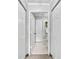 Hallway leads to a bathroom with white tile floors and an open doorway into the bathroom at 1075 Peachtree Walk # A-307, Atlanta, GA 30309