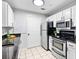Efficient kitchen design with white cabinets, granite countertops, stainless steel appliances, and tile flooring at 1075 Peachtree Walk # A-307, Atlanta, GA 30309